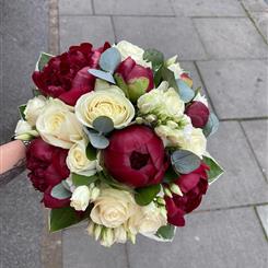 Burgundy peonies white roses white lizzi and hosta leaves 